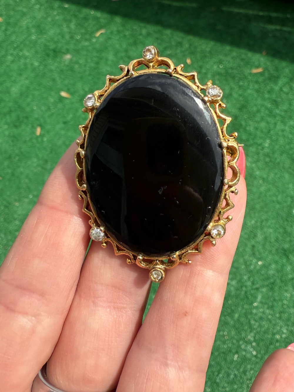 Vintage Gold-Tone Black Onyx Oval Brooch with Rhinestone Accent Stones.